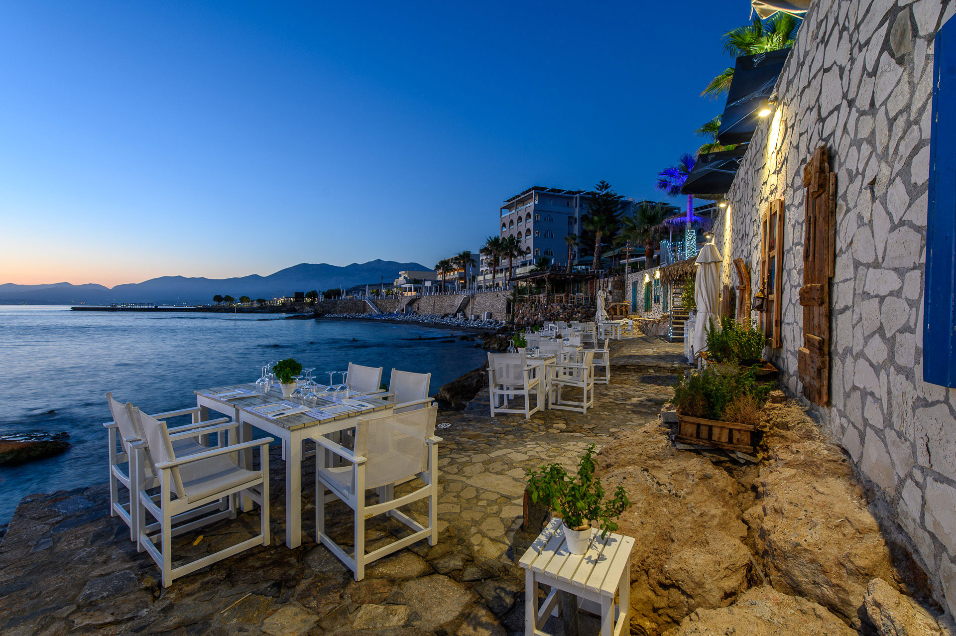 Cretan Blue Beach Hotel table seats in a tavern by the sea, at sunset