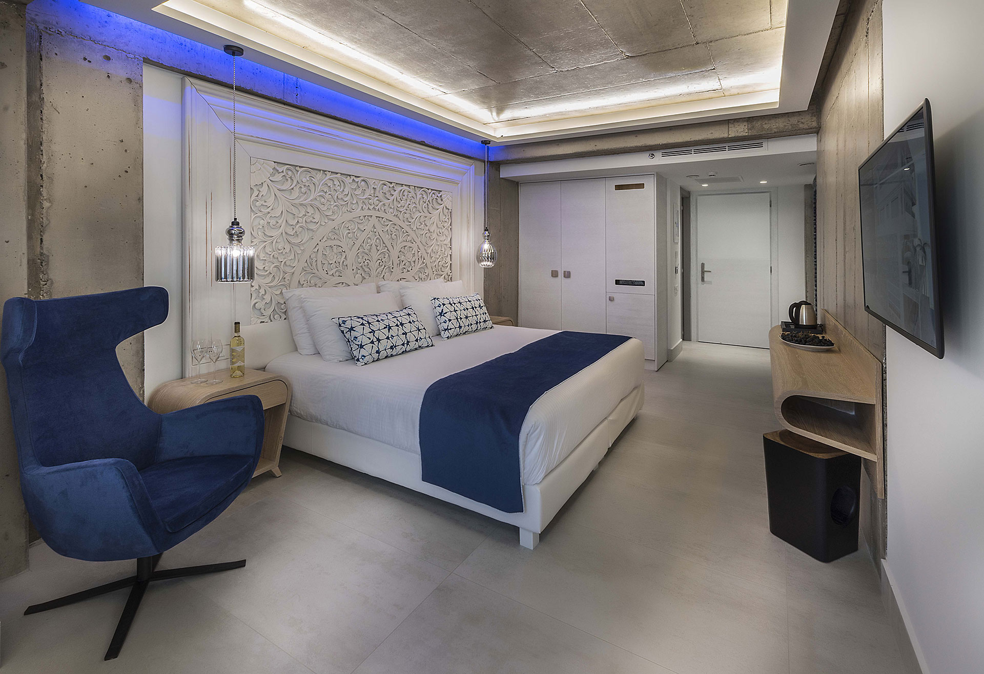 Cretan Blue Beach Hotel hotel room with double bed, blue armchair and TV