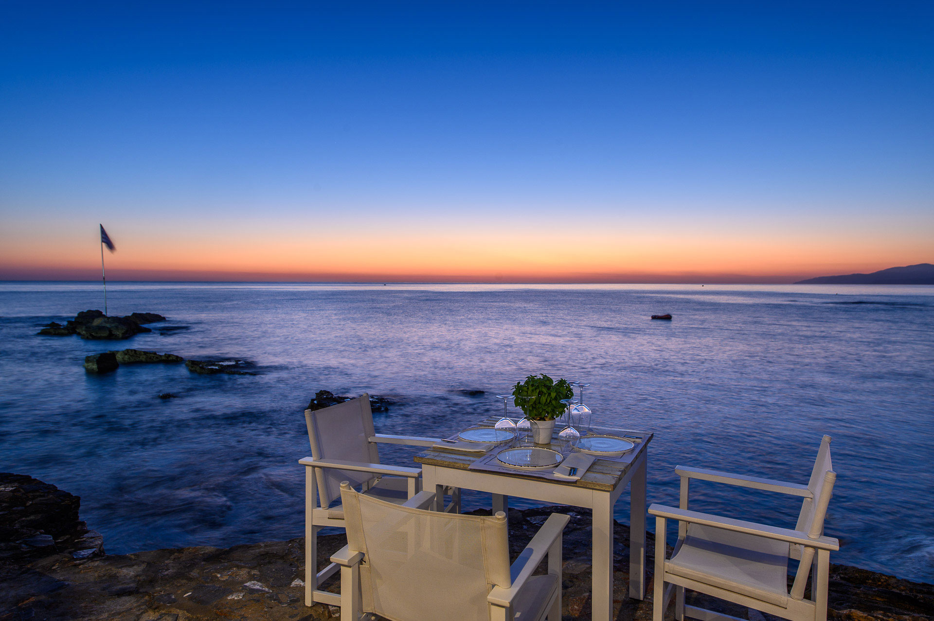 Cretan Blue Beach Hotel restaurant by the sea at the sunset time, with blue and red sky