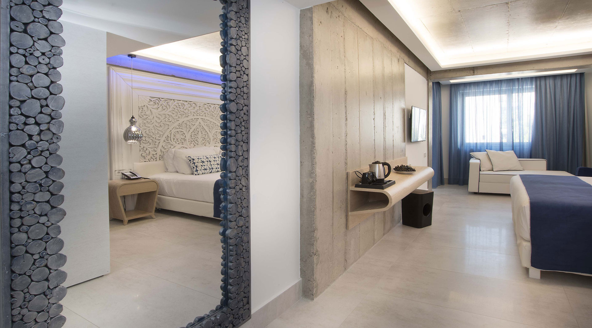 Cretan Blue Beach Hotel hotel room with couch, blue curtains and large mirror